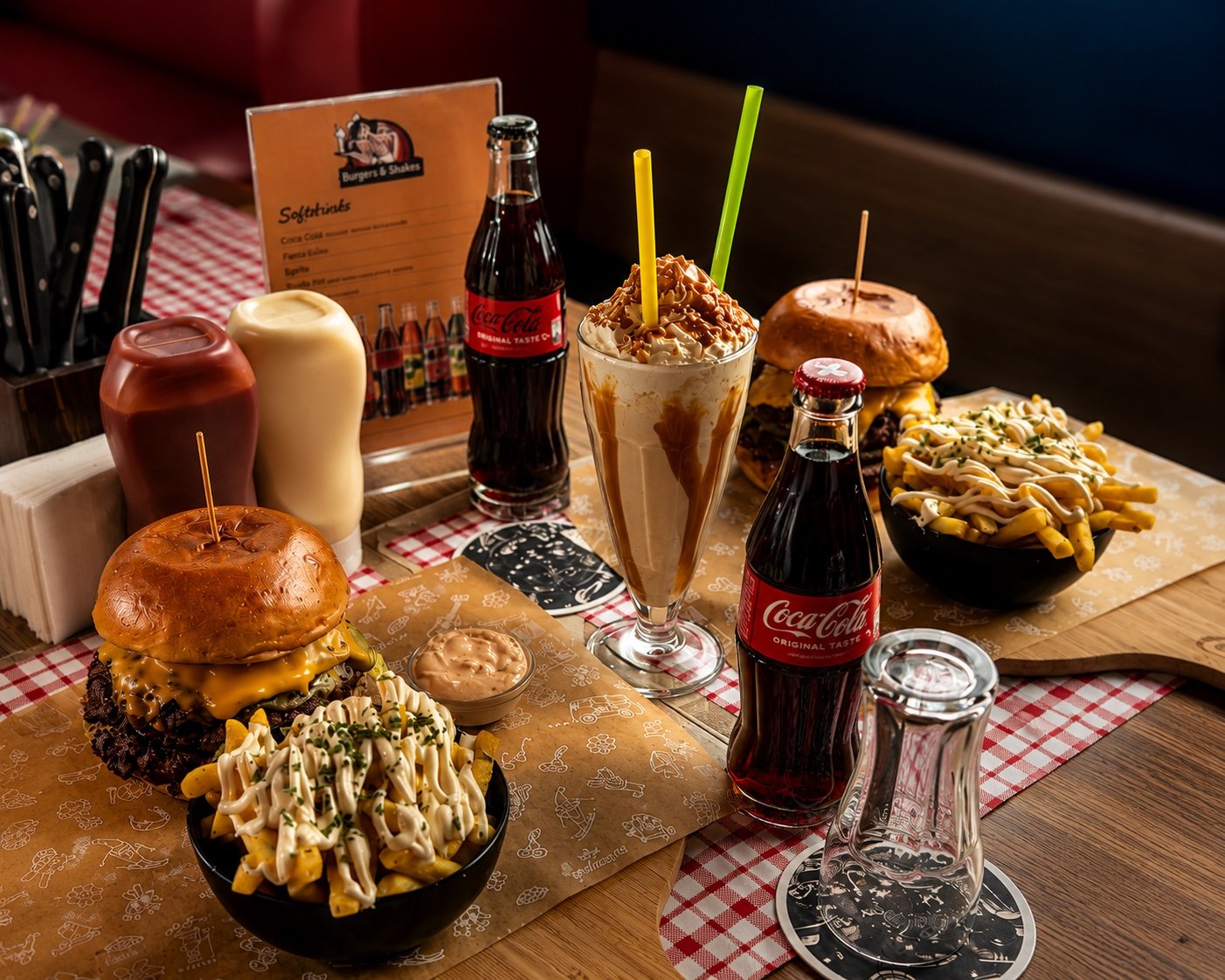 Gedeckter Tisch mit Burgern, Loaded Fries, Milkshake und Coca-Cola bei Burgers & Shakes in Opfikon